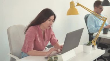 Kadın işçi ev ofisindeki ekrana bakıyor. Mutlu Milenyum Asyalı etnik köken kız öğrencileri. Güzel, güler yüzlü, kendine güvenen genç bir kadın başarılı bir ticaret operasyonu yaptı. İş kadını çevrimiçi dizüstü bilgisayar kullanıyor.