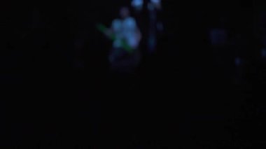 Rock konserinde dans eden bir kızın silueti. Eğlence ve geçmiş kavramı. Hayranları ve yıldızları olan bir gece kulübünde canlı performans. İnsanlar ellerini kaldırıp şarkı söylüyorlar..