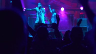 Hip-hop yıldızı hayranlarının önünde sahneye çıkıyor. İnsanların ellerini havaya kaldırdığı bir kulüpte canlı konser performansı. Parti ve eğlence kavramı. Müzik gecesi konseri.