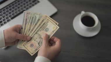 Dolar banknotları olan erkek eller. Amerika 'nın parasını sayan adam kafedeki masaya para yatırıyor ve çalışıyor. Ödeme, finans konsepti. Para ve kazançlar