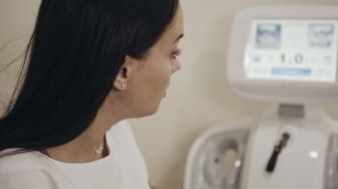 Kadın kozmetolojist yüzüne hastayla ilgili işlem sırasında yakın çekim. Kadın yüz ameliyatı yapıyor, sakin ve aklı başında, profesyonel görünümlü..