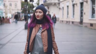 Hipster kız turist tatili sırasında eski şehir merkezini keşfediyor. Çekici genç kadın gezgin ellerinde bavulla şehir caddesinde yürüyor. Macera, gezi ve turizm konsepti