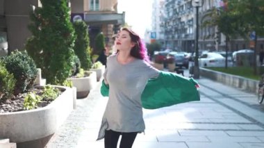 Kız gülümsüyor, poz veriyor ve eğleniyor. Summer City caddesinde yürüyen parlak saçlı neşeli genç bir hipster kadının yakın plan portresi. İnsanlar ve tarz kavramı.