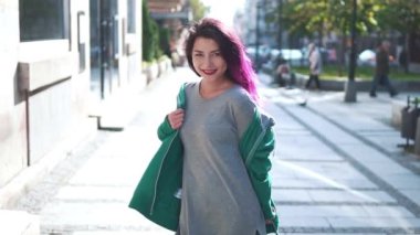 İnsanlar ve tarz kavramı. Summer City caddesinde yürüyen parlak saçlı neşeli genç bir hipster kadının yakın plan portresi. Kız gülümsüyor ve poz veriyor.