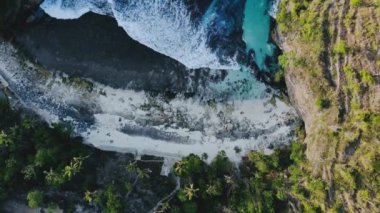 Seyahat kavramı. Deniz gelgitlerinin kayalıklara çarpması için muhteşem bir manzara. Gök mavisi deniz dalgaları, bol köpüklü kayalar ve ağaçlarla dolu inanılmaz tropikal doğa. Doğal güçlerin gösterimi.