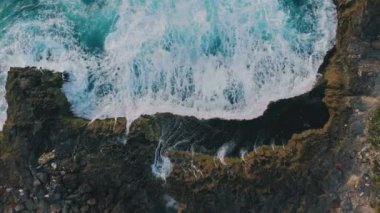 Tropikal kayalık adaların ve dalgaların havadan görünüşü. Şeytanlar lagünü yırtar. Gök mavisi dalgaların uçurumla buluşması, yükselen deniz köpüğünün inanılmaz arka planı. Doğal güç ve güzelliğin nefes kesici manzarası. Seyahat kavramı