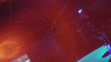 Rampada paten numarası yapan adamın silueti. Karanlık stüdyoda sahne ışıklarında etkileyici yetenekler sergileyen bir genç. Gece hayatı gençlik kültürüne bir bak. Yaşam tarzı kavramı, serbest.