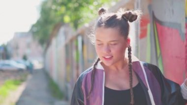 Özgürlük, yaşam tarzı, kültür konsepti. Güzel genç kız yazın şehir duvarına sprey boyayla renkli bir grafiti yapıyor. Yaratıcı sanat. Yetenekli yeniyetme kız öğrenci resim çiziyor..