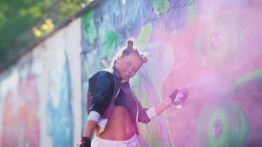 Güzel genç kız sıcak bir yaz gününde havaya sprey püskürtüyor. Cesur yaratıcılık. Özgürlük, yaşam tarzı, kültür konsepti. Yaratıcı sanat. Yetenekli yeniyetme kız öğrenci resim çiziyor.