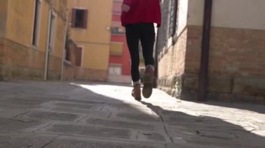 Venedik 'te parlak gün ışığında ilham arıyorum. Enfes, genç Asyalı, şık, kırmızı bir süveter giyen, antik dar sokaklar boyunca uzun bir geçmişi olan, yürüyen ve dönen bir kadının arka görüntüsü..