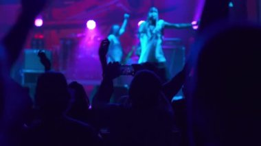 Hip-hop yıldızı hayranlarının önünde sahneye çıkıyor. İnsanların ellerini havaya kaldırdığı bir kulüpte canlı konser performansı. Parti ve eğlence kavramı. Müzik gecesi konseri.