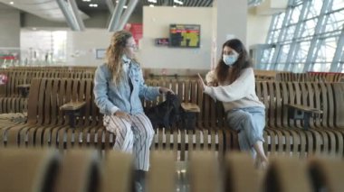 Sosyal uzaklık. Havaalanındaki tıbbi maskeli kadın diğer yolcuya kuralları hatırlatıyor. Diğer yolcularla mesafeyi kırma. Koronavirüsten korunma. Salgın sırasında seyahat