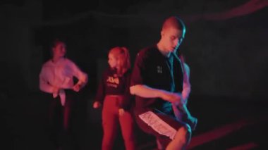 Patenli adam dans figürleri yapıyor. Karanlık stüdyoda spot ışıkları altında kayarken break dans yapan bir adam. Gece yaşam tarzının bir parçası olarak aşırı hareketlilik. Gençlik kavramı, gece hayatı.