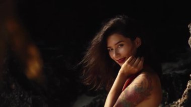 Güzel Asyalı kız gülümsüyor. Sıcak yaz gününde hasır şapkalı ve kırmızı elbiseli güzel melez bir kadın. Güzellik, seyahat, tatiller, moda konsepti ve yaşam tarzı.