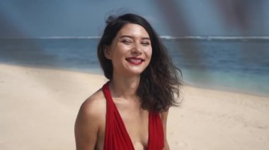 Zaman parmaklarının arasından kum gibi akıyor. Mutlu Asyalı kadın kumdan eller döküyor. Güzellik, seyahat, zaman kavramı. Hasır şapkalı neşeli Asyalı kadın parmaklarının arasındaki kumu temizliyor..