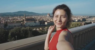 Floransa 'da güneşli havanın tadını çıkaran güzel bir genç kız. Yaşam tarzı olarak seyahat etmek. Sosyal ağdaki hikayeleri için akıllı telefondan selfie çeken gülümseyen Asyalı kadının portresi.