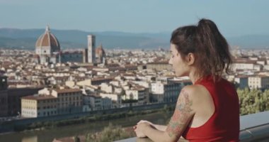 Avrupa şehrinin atmosferinin tadını çıkaran güzel bir kız. Santa Maria del Fiore 'un arka planında gün batımında güzel şehre bakan Asyalı turist esmerinin arka görüntüsü..