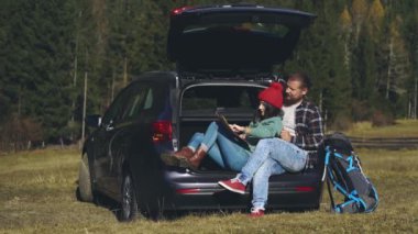 Uzun karantina sonrası yolculuklarında olan sevimli hippi genç bir çift. Toplumsal uzaklık. Güzel aşıklar harita üzerinde çalışıyorlar ve tatilleri boyunca arabada oturuyorlar..