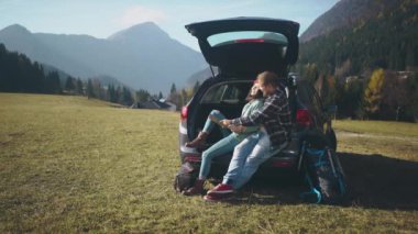 Güzel aşıklar harita üzerinde çalışıyorlar ve tatilleri boyunca arabada oturuyorlar. Uzun karantina sonrası yolculuklarında olan sevimli hippi genç bir çift. Sosyal uzaklık.
