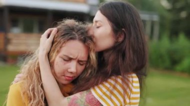 Bir kadın aile içi şiddet kurbanını sakinleştirecek ya da teselli edecek. Yüzünde yara izi olan bir kadın ağlıyor ve arkadaşına sarılıyor. Aile sorunu ve tacizci ilişki kavramı. Kadın kocası yüzünden acı çekiyor..