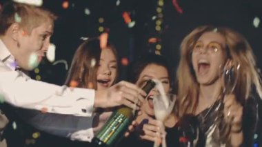 Partideki arkadaşlar yeni yılı ya da Noel 'i kutluyorlar, alkol, şampanya ya da köpüklü şarap açıyorlar, bardağa döküyorlar, gülümsüyorlar ve gülüyorlar. Mutlu hipster Noel arifesinde birlikte vakit geçiriyor..