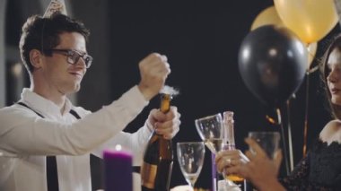 Milenyum arkadaşları partide masada oturuyor, şampanya şişesini açıyor ve bardaklara köpüklü şarap döküyorlar. Çocuklar yeni yılı ya da Noel 'i kutluyor, gülümsüyor, gülüyor, konuşuyor ve iletişim kuruyor..