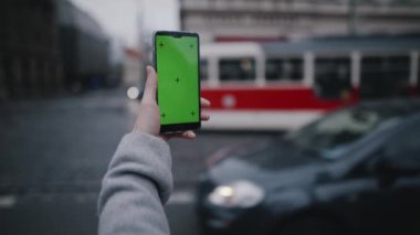 Kız avucunun akıllı telefon ya da krom anahtar ya da yeşil ekran ile yakın çekimi. Gezmek için mobil uygulama kullanan, fotoğraf ya da video çeken, taksi çağıran ya da uçak rotası çizen bir kadın. Modern teknoloji kavramı.