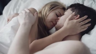 İç çamaşırlı genç çift sabah uyandıktan sonra tutkuyla öpüşüyor. Samimiyet anı. Sevgi. Seks, aile, ilişki kavramı. RED 4K 'de çekilmiştir..