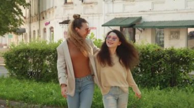 Dışarıda çıkan mutlu lezbiyen Igbt çifti. Kıvırcık sarışın kadın ve Asyalı kız arkadaşı parkta yürüyor. Aynı cinsiyetten insanlar birlikte vakit geçirip eğleniyorlar. İlişki, özgürlük ve aşk kavramı.