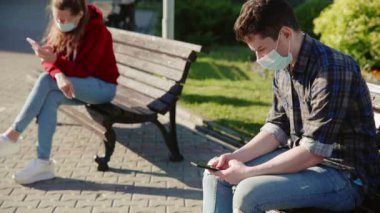 Kız ve erkek sosyal olarak birbirlerinden uzaklaşıyorlar. İnsanlar akıllı telefonları ya da cep telefonları aracılığıyla iletişim kuruyor ve dışarıdaki farklı banklarda tıbbi maskelerle oturuyorlar. Güvenli mesafeyi koru.