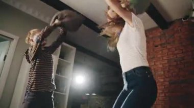 Mutlu Avrupalı anne ve genç oğul yastık savaşı ve kendini tecrit ve karantina sırasında yatakta zıplama. Genç sarışın anne çocuğuyla eğleniyor. Çocukluk, annelik ve aile kavramı.