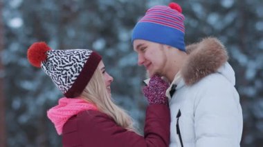 Komik, kaygısız genç çift birlikte gülüyor. Örgü şapkalı aşıklar kış ormanı yakınlarında buluşuyorlar. İlişki ve aşk kavramı. Güzel mutlu insanlar birlikte eğleniyorlar.