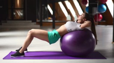 Formda genç bir kadının spor salonunda briç oynaması. Güzel, sportif bir kadın fitness kulübünde karın eğitimi için uygun tekniği gösteriyor. Eğitim, sağlık, yaşam tarzı kavramı.