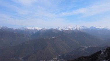Sisli, güneşli bir günde beyaz karlı zirvelerde insansız hava aracının muhteşem görüntüsü. Yukarıdan karla kaplı dağ sırasının havadan görüntüsü. Seyahat kavramı, ilham verici, doğa, kış.