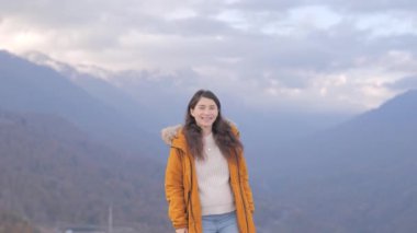 Dağda durup gülümseyen ve ellerini kaldıran mutlu Asyalı kadın portresi. Seyahat, özgürlük konsepti. Kaygısız güzel kız kameraya bakıyor..