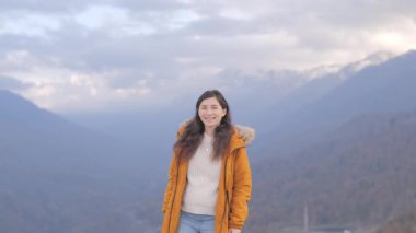 Dağda durup gülümseyen ve ellerini kaldıran mutlu Asyalı kadın portresi. Seyahat, özgürlük konsepti. Kaygısız güzel kız kameraya bakıyor..