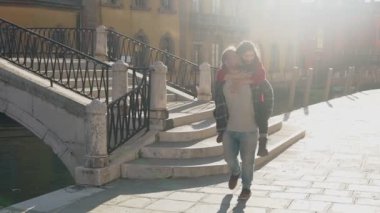 Genç aşık hippi çift uzun bir geçmişi olan güzel bir ülkede eğleniyor. Aşk kavramı. Yakışıklı Avrupalı adam Venedik sokaklarında muhteşem Asyalı kadınını sırtında taşıyor.