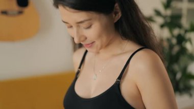 İç çamaşırı giyen hamile bir kadının, kameraya bakan portresi. Genç bir anne hamileliğinin tadını evde çıkarıyor. Annelik ve aile kavramı