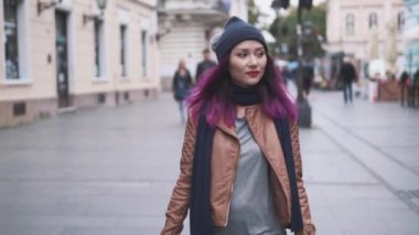 Hipster kız turist tatili sırasında eski şehir merkezini keşfediyor. Çekici genç kadın gezgin ellerinde bavulla şehir caddesinde yürüyor. Macera, gezi ve turizm konsepti