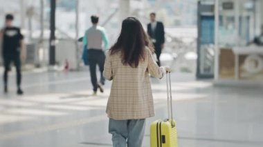 Genç bir kadının silueti platforma doğru yürüyen merdivene doğru gidiyor. Güzel bir istasyonda bavulla trene giden bir kız. İş seyahatine ya da tatile hazırlanan bir kadın. Seyahat kavramı.