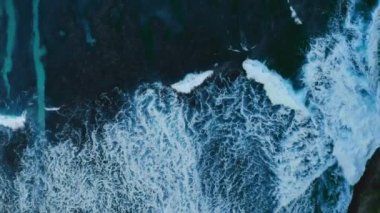 Gök mavisi deniz dalgalarının tropikal adada kum kıyılarıyla buluştuğu tepeden aşağı bir sahne. Renkli su manzarası, yükselen köpük ve kumsal. Renkli doğanın rahatlatıcı bir resmi. Alan ve arkaplan kavramını kopyala