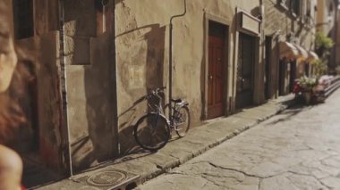 İtalyan şehrinde sokakta yürüyen mutlu genç turistin arka manzarası. Esmer kız Avrupa 'yı keşfediyor ya da keşfediyor, seyahatten, maceradan ya da turizmden hoşlanıyor. Tasasız seyahat kavramı.