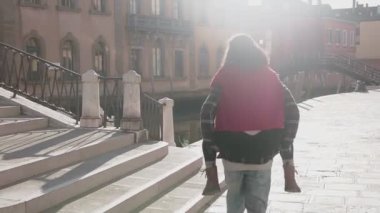 Yakışıklı Avrupalı adam Venedik sokaklarında muhteşem Asyalı kadınını sırtında taşıyor. Genç aşık hippi çift uzun bir geçmişi olan güzel bir ülkede eğleniyor. Aşk kavramı.