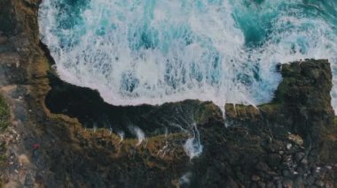 Tropikal kayalık adaların ve dalgaların havadan görünüşü. Şeytanlar lagünü yırtar. Gök mavisi dalgaların uçurumla buluşması, yükselen deniz köpüğünün inanılmaz arka planı. Doğal güç ve güzelliğin nefes kesici manzarası. Seyahat kavramı