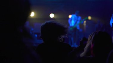 İnsanların ellerini havaya kaldırdığı bir kulüpte canlı konser performansı. Parti ve eğlence kavramı. Hip-hop yıldızı hayranlarının önünde sahneye çıkıyor. Müzik gecesi konseri.