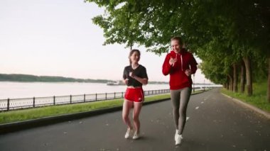 Parkta koşan kırmızı elbiseli iki genç kız. Arkadaşlarınla vakit geçir. Spor yaparken birbirleriyle iletişim kuran iki güzel kadın. Sabah ya da akşam nehir kenarında koşarken..