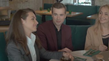 Kafede masada otururken iş arkadaşlarının grup portresi. İş ortakları iş ve restoranda yapılacak projeleri tartışıyor. Takım çalışması kavramı, yaşam tarzı, boş zaman.