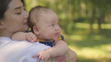 Anne, parkta yürürken bebeği elinde tutuyor. Bebeklere sarılan, çocuğunu seven ve önemseyen bir kadın. Anne dünyayı bebeğe gezdiriyor, birlikte duygusal anlar yaşıyor..