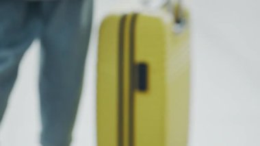 Havaalanındaki kayıt standına giden genç bir kadın. Güzel kız kamerayla gidiyor, bavulu hazırlıyor. Kız iş seyahatine ya da tatile hazırlanıyor, uçuşa hazırlanıyor. Seyahat, ulaşım kavramı.