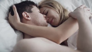 Romantik çift yatak odasında yatarken ön sevişme yapıyor. Çıplak adam ve sutyen takmış kadın samimiyet ve öpüşmenin tadını çıkarıyorlar. Şefkatli aşıklar baştan çıkarıcı ve arzu hissederler. Erotizm, tutku.